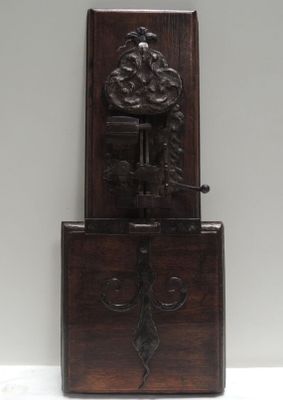 une horloge ancienne en bois, dotée d'un cadran sculpté et posée sur un socle