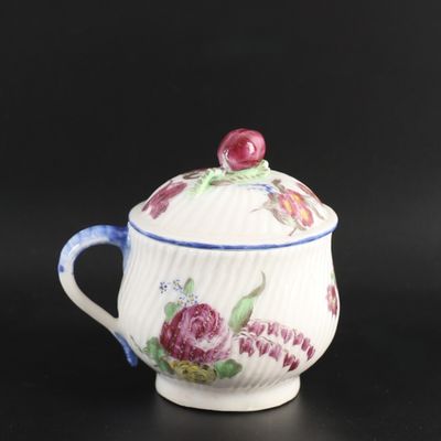 un gros plan d'une tasse avec un couvercle posée sur une surface noire