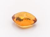 a close up of a faceted citrine stone on a white surface