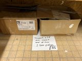 un panneau posé par terre devant une pile de cartons