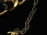 a close up of a gold chain with a black and gold bracelet
