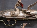 a gun that is sitting on a table next to a pair of scissors