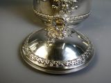 a silver plate with a flower on it on a table
