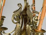 a brass chandelier with a candle holder and umbrellas on it