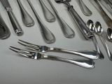 a lot of silver spoons and forks laid out on a table