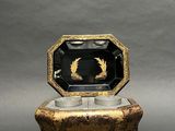 an image of a black and gold box sitting on top of a table