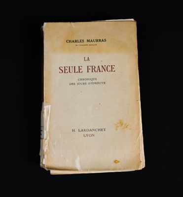 un vieux livre posé sur une table à côté d'un fond noir