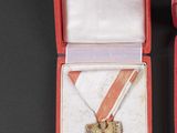 a red box with a gold medal and a red ribbon