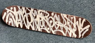 a skateboard with graffiti on it laying on the floor