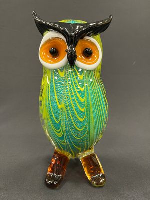une figurine de chouette en verre posée sur une table