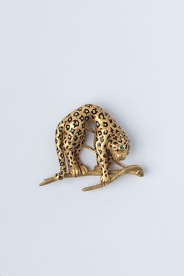 broche représentant un léopard doré posé sur une branche, sur un fond blanc