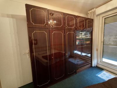 une photo d'une chambre à coucher avec un lit et une armoire