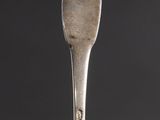 a close up of a spoon on a table with a black background
