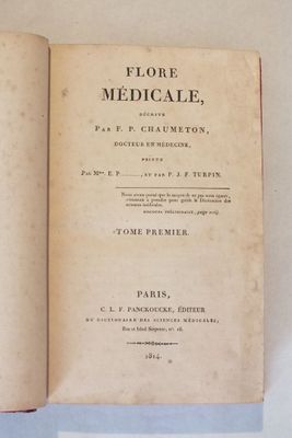 un livre ouvert sur une table blanche, sur fond bleu