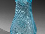 a blue glass vase that is sitting on a table