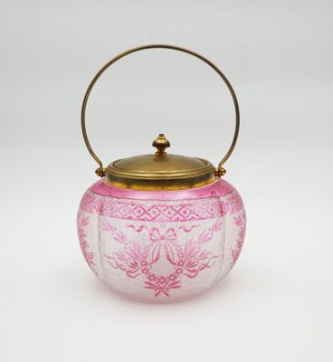 a pink and gold teapot with handle on a white background