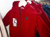 three jackets hanging on a clothes rack in a room