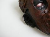 un gros plan d'un masque sur une surface blanche