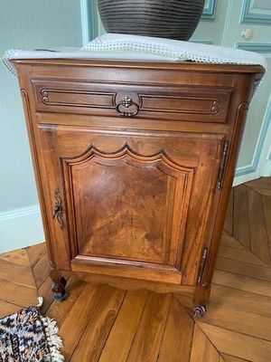a wooden cabinet with a marble top on a hard wood floor