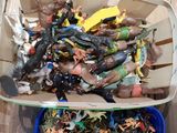 a lot of action figures in a basket on the floor