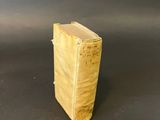 an old book sitting on top of a table on a black surface