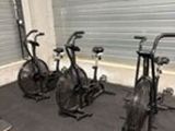 several exercise bikes are lined up in a row in a gym