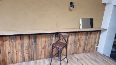 an image of a bar with a stool and a mirror