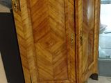 a wooden cabinet with a marble top on a tile floor