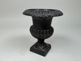 a black vase that is sitting on a white surface