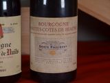 two bottles of wine sitting on a table next to each other