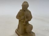 a statue of a man sitting on a stool with a dog