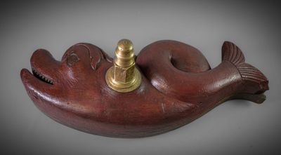 an image of a wooden fish with a brass plate on it