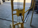 a yellow hand truck with a crane attached to it