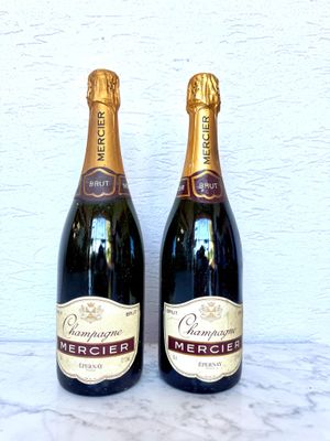 deux bouteilles de champagne posées l'une à côté de l'autre sur une table