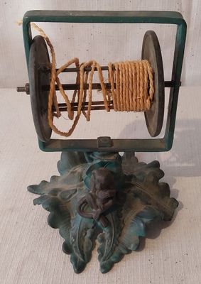 une bobine avec une corde, posée sur un support posé sur une table