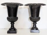 two black vases sitting on a white table