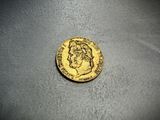 a close up of a gold coin on a gray surface