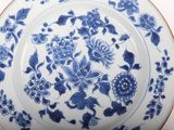 a blue and white plate with flowers and birds on it