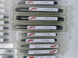 several pens are lined up in a row on a white surface