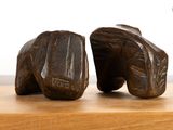 two wooden sculptures of a pair of shoes on a table