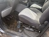 l'intérieur d'une voiture dont la portière est ouverte et le siège conducteur rabattu