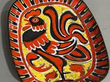 a red and yellow plate with a rooster on it