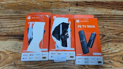 three boxes of nintendo wii remotes sitting on a wooden surface