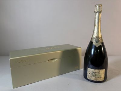 une bouteille de champagne à côté d'un coffret sur une table