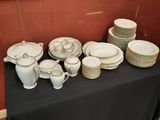 many plates and cups on a table with a black table cloth