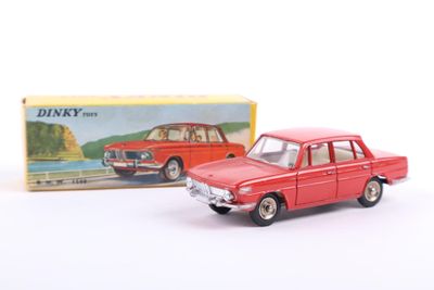 a red toy car next to a box of dinky cars