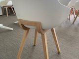 a white chair with wooden legs in the middle of a room