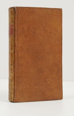 un livre brun posé sur une table blanche