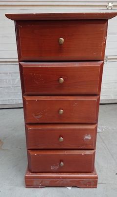 une vieille commode en bois posée sur le trottoir