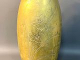 a yellow vase with a black lid sitting on a table